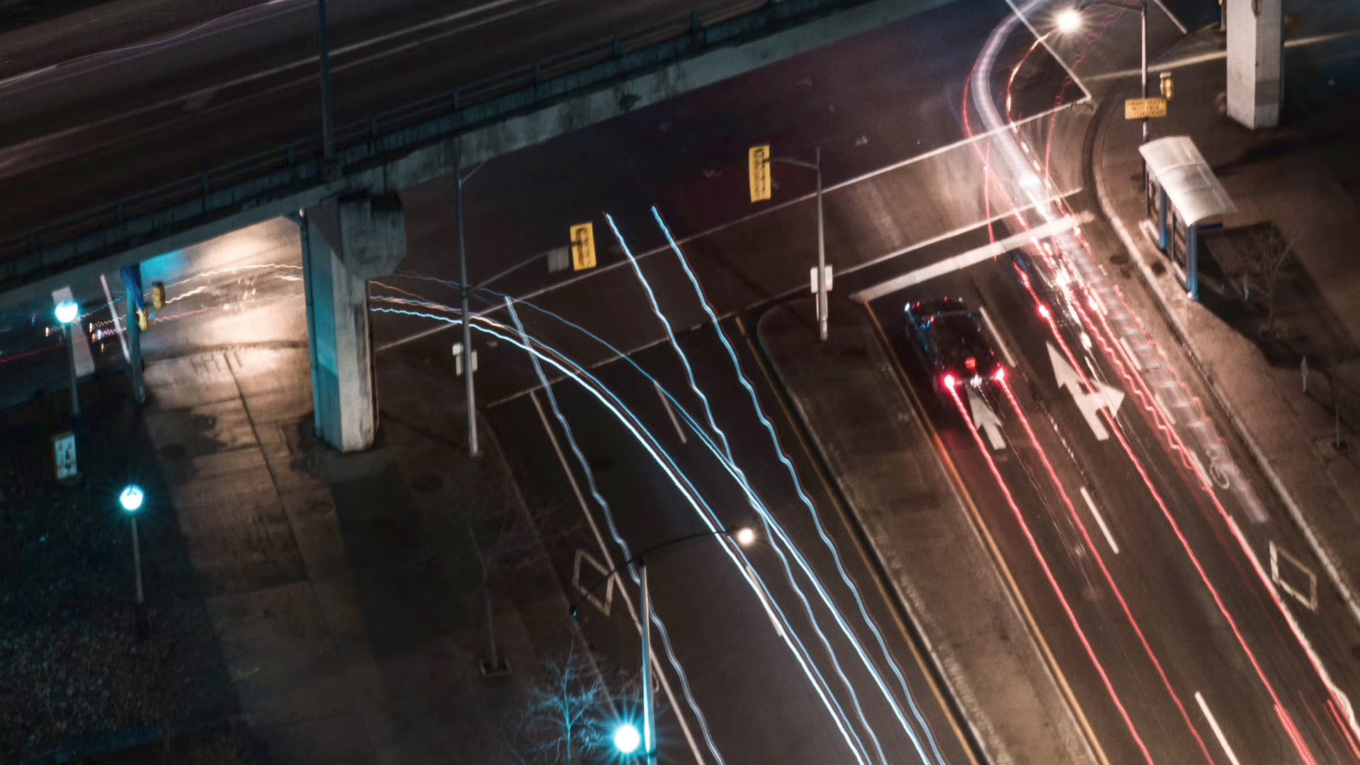 A picture of a highway with some cars at night.